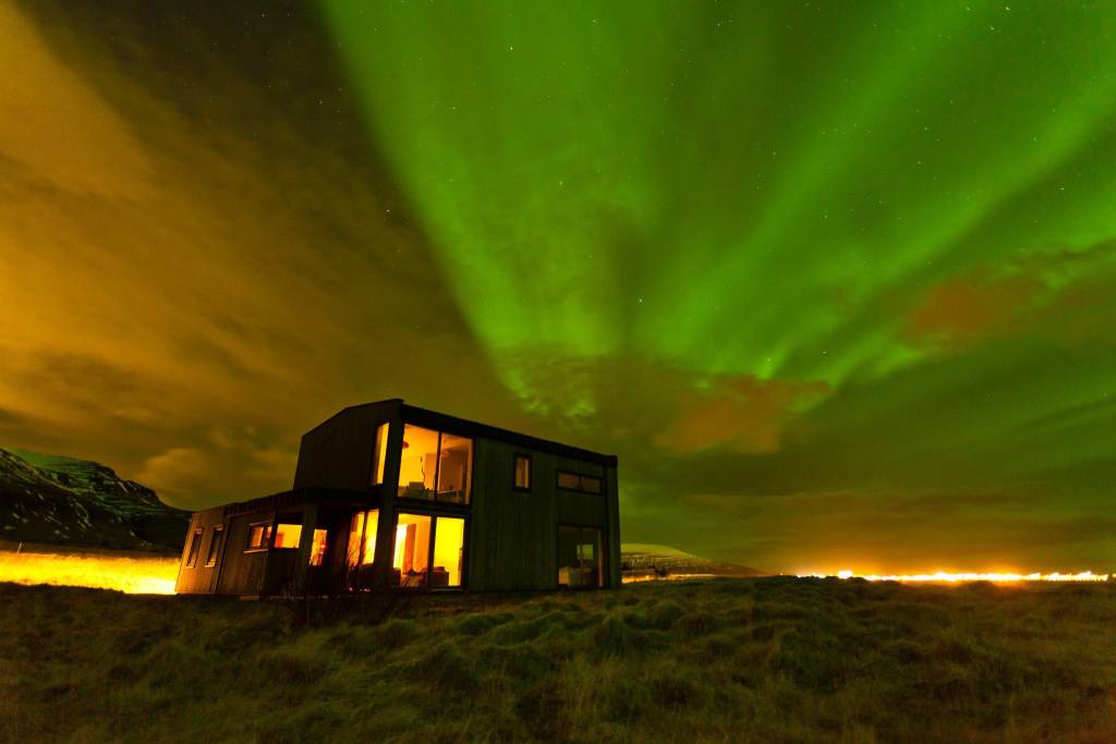 northern lights iceland house by the ocean